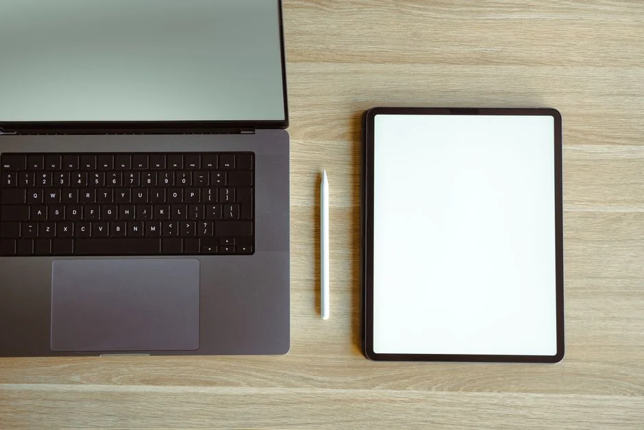 A polished office desk arrangement showcasing Apple devices: an iMac, MacBook, and iPad.